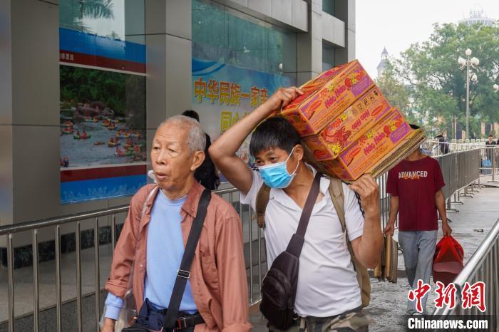 一名男子背着三箱越南商品入境中国。
